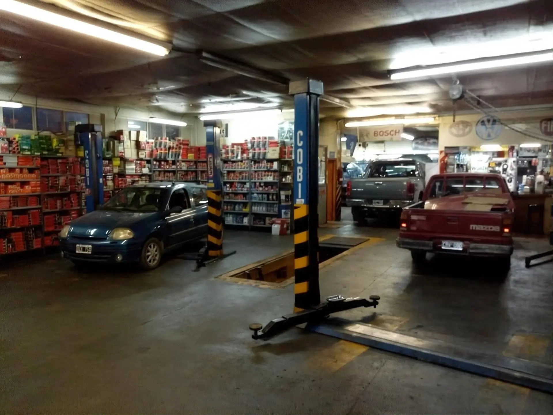 Playa de trabajo con elevadores de dos columnas y varios vehículos en atención